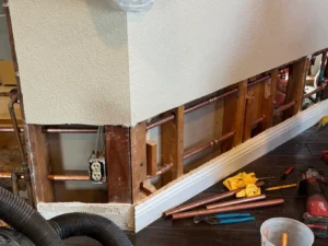 Water leak detection technician using leak detectors to locate a hidden plumbing leak causing a high water bill.